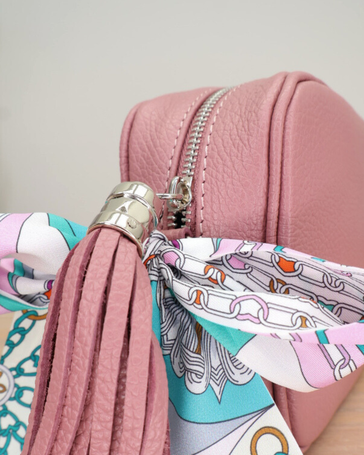 Nahaufnahme des Reißverschlusses der altrosa Lederhandtasche „Isolde“ mit Bandana-Anhänger.