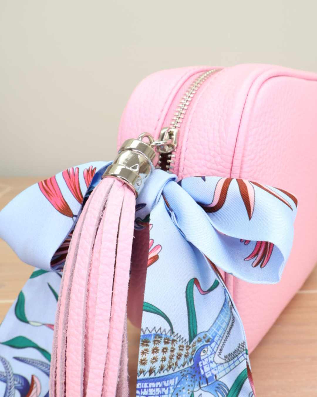 Nahaufnahme des Reißverschlusses der Zuckerwatte Lederhandtasche „Isolde“ mit Bandana-Anhänger in hellblau.