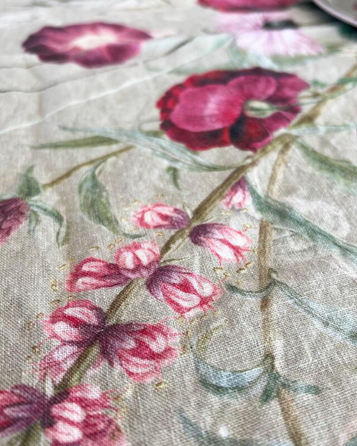 Nahaufnahme der Blumenmuster auf dem Leinen-Tischläufer "Blossom Garden". Die natürliche, leicht strukturierte Oberfläche des Leinens ist charakteristisch.