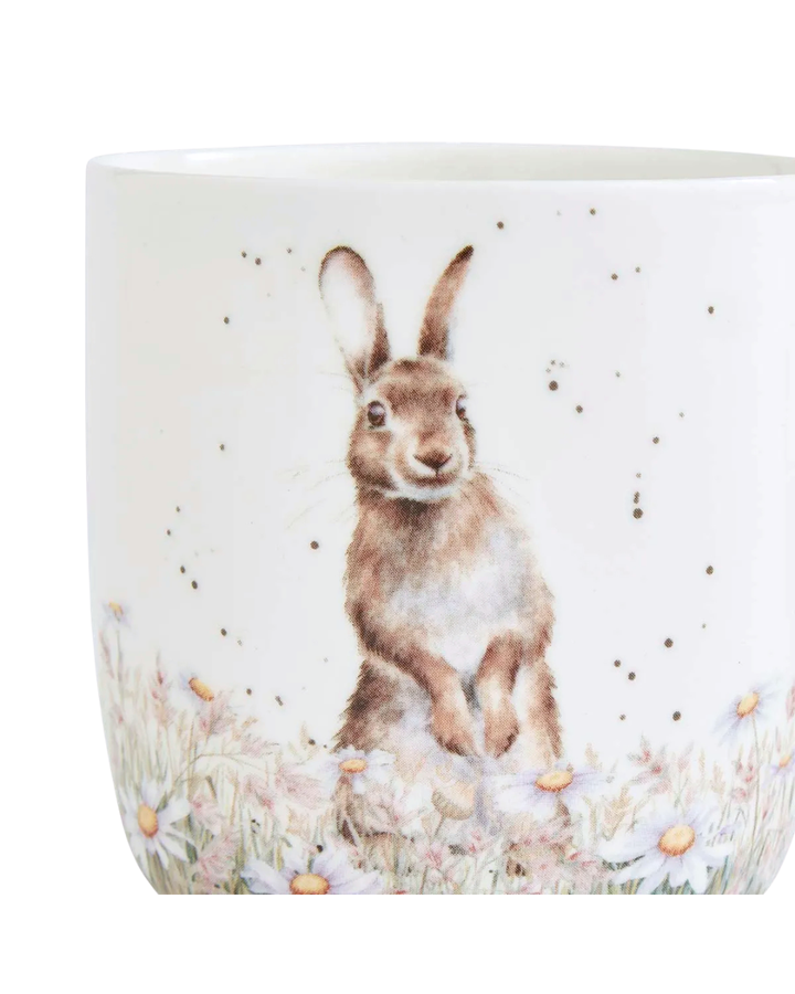 Nahaufnahme der Hasen Tasse von Wrendale Designs auf weißen Hintergrund. Auf der Tasse ist ein Hase auf einer Blumenwiese Blumenwiese zu sehen welcher aufrecht in die Kamera schaut.