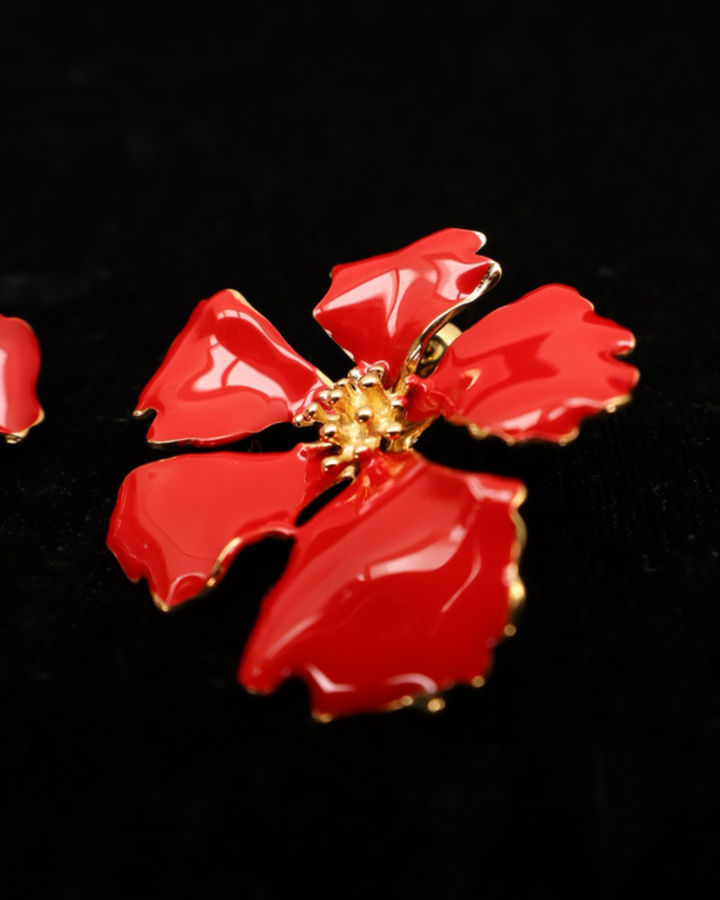 Vorderseite der roten Emaille-Blumen Ohrringe von Dottilove auf schwarzer leicht glitzernder Decke.