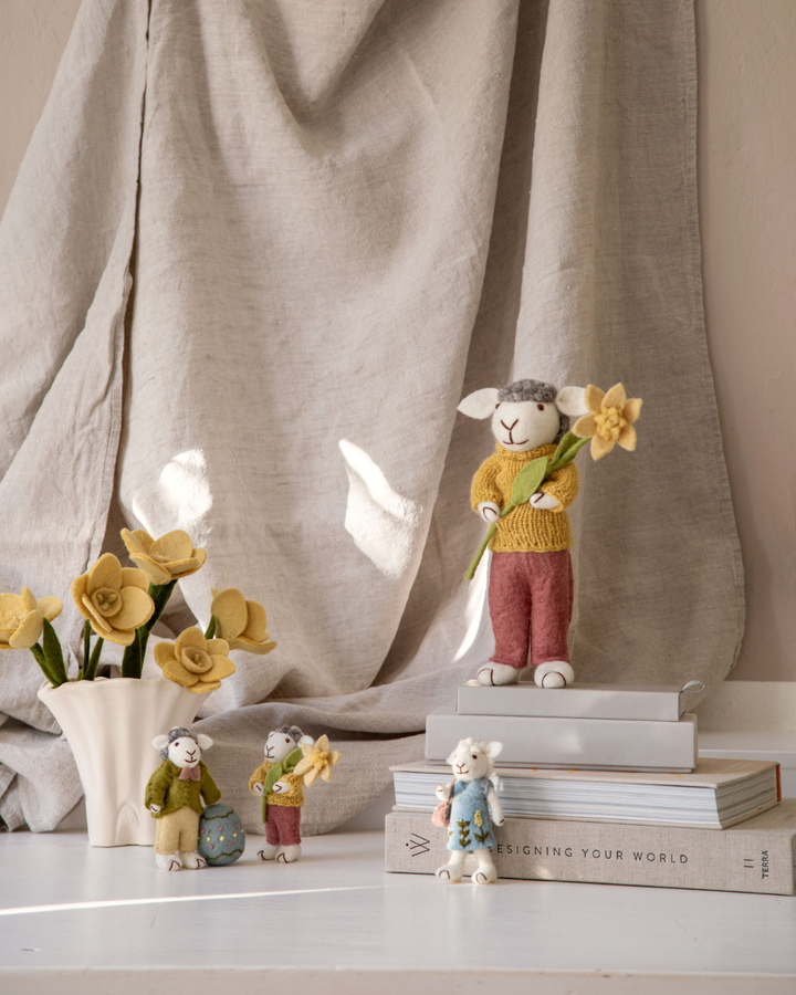 Frühlingsdeko mit Filzblumen und Figuren, Narzissen in Vase arrangiert.