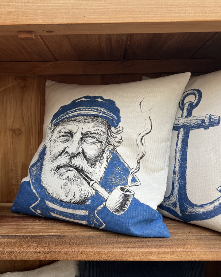 In einem braunen Schrank dekoriertes maritimes Kissen Old Salt von Sander mit einem Seemann-Motiv.