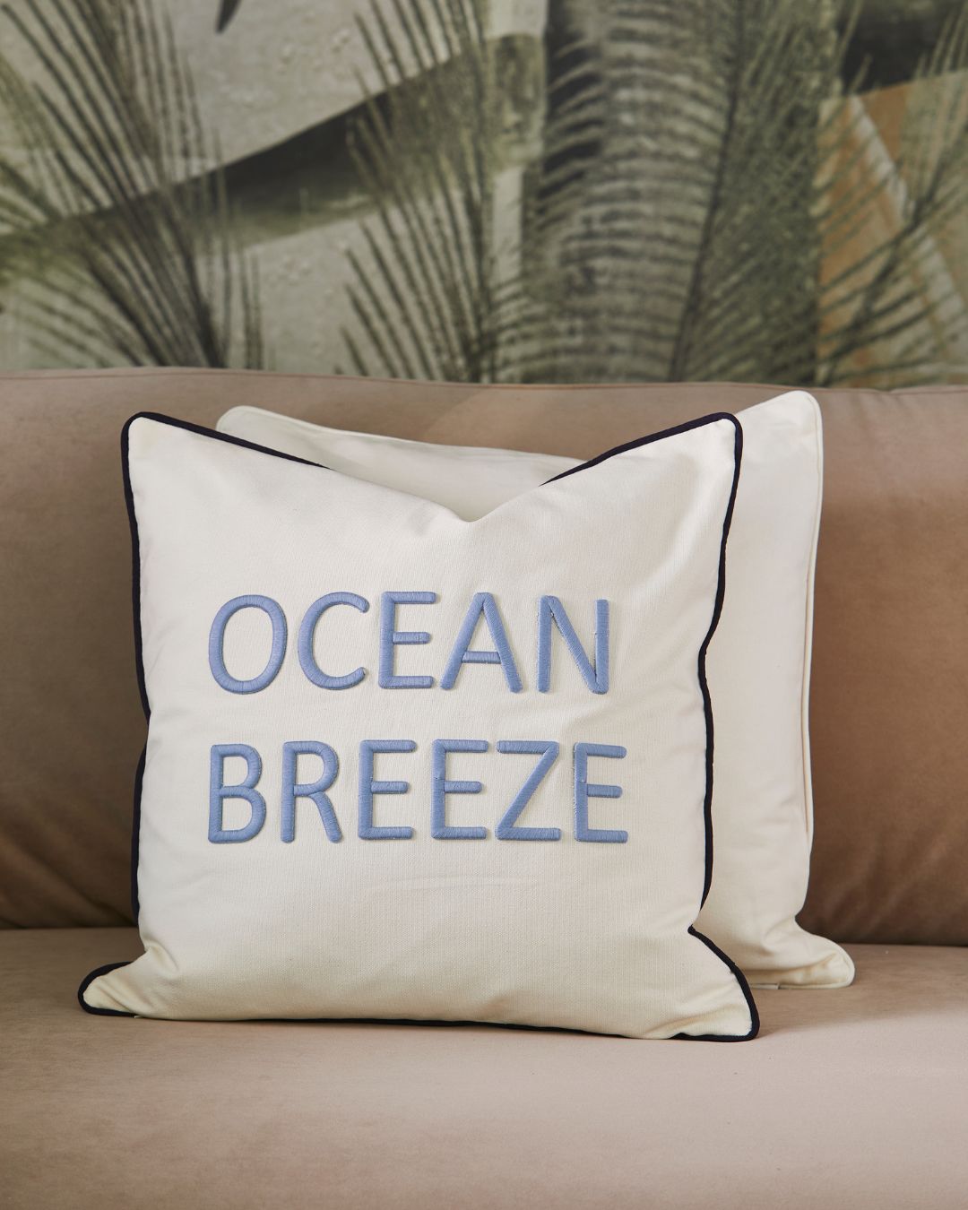 Ocean Breeze Kissenbezug von Rivièra Maison auf einer gemütlichen Couch dekoriert.