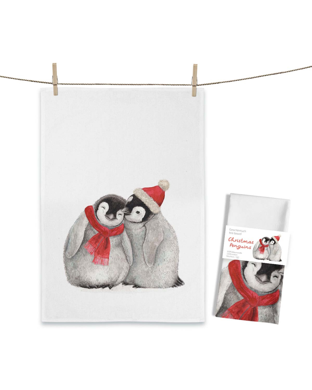 Pinguin Geschirrtuch Christmas Penguins von Maluu mit Verpackung, winterliches Motiv mit zwei jungen Pinguinen auf weißem Baumwolltuch.