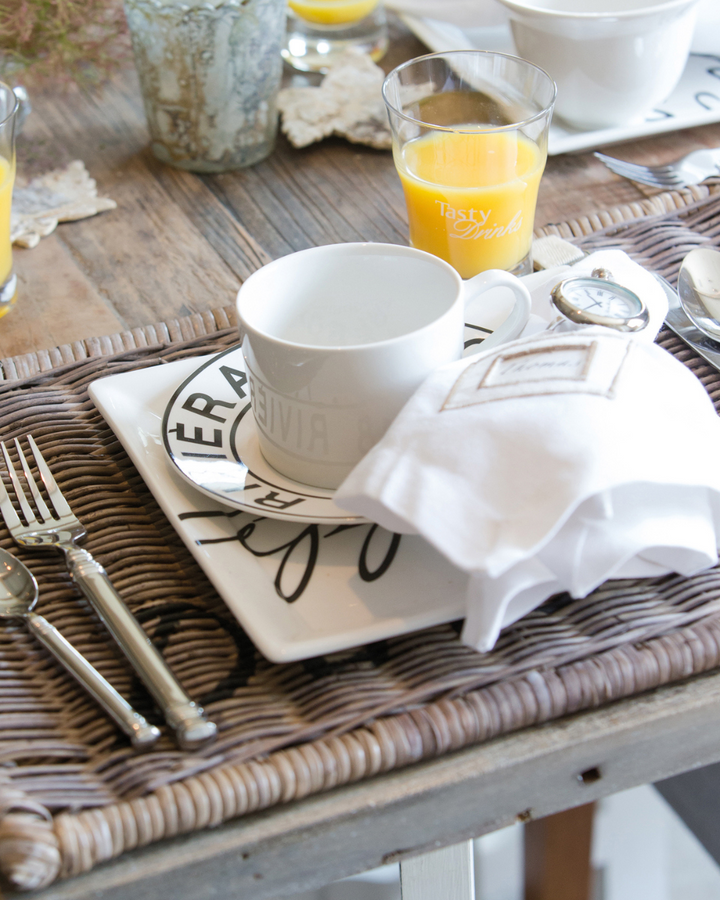 Das Rattan Diner Platzset von Rivièra Maison ist auf einem Frühstückstisch dekoriert.