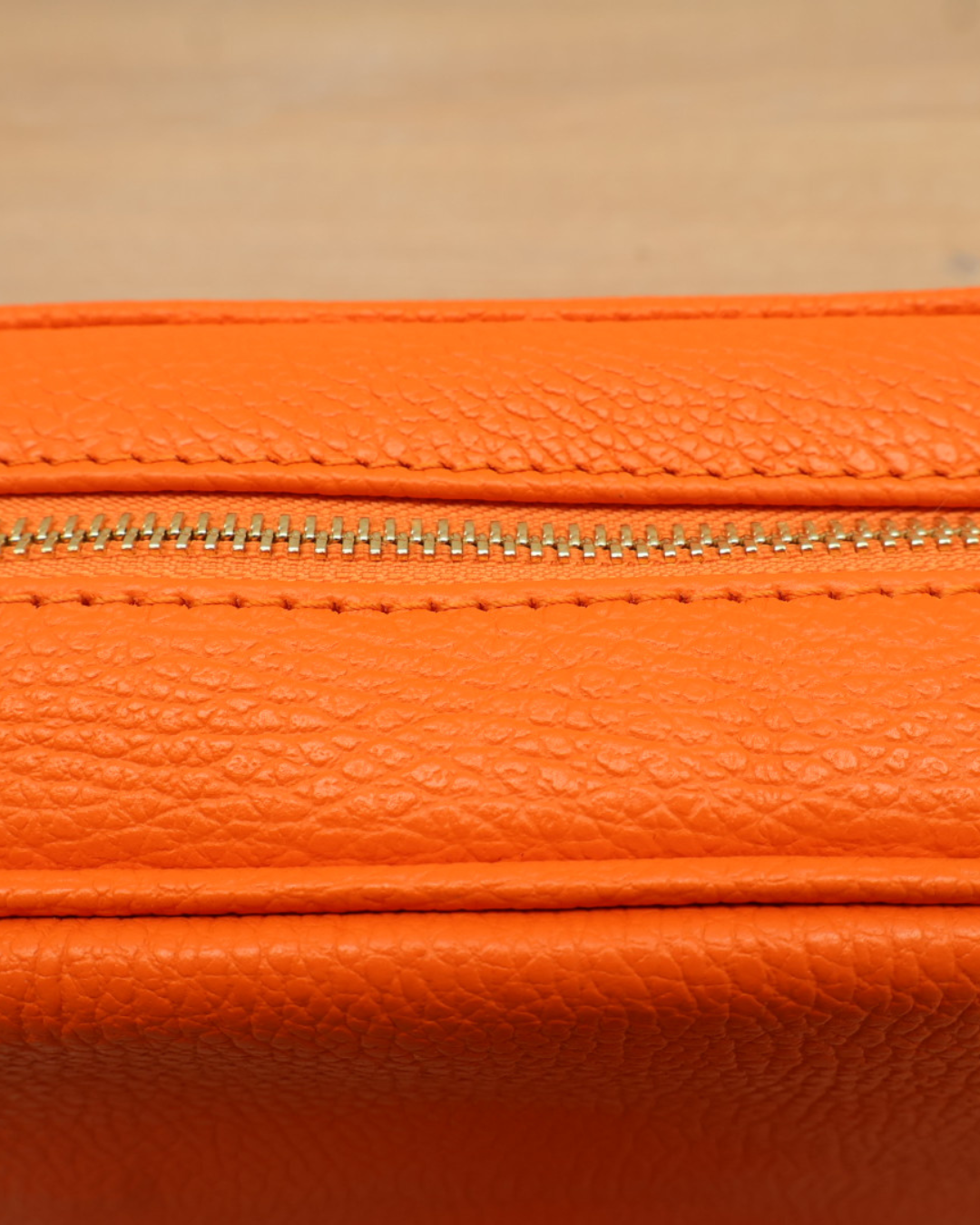 Nahaufnahme des Reißverschlusses der orangen Lederhandtasche „Isolde“.