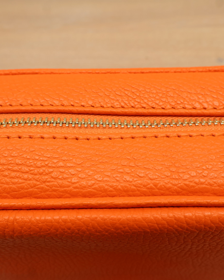 Nahaufnahme des Reißverschlusses der orangen Lederhandtasche „Isolde“.