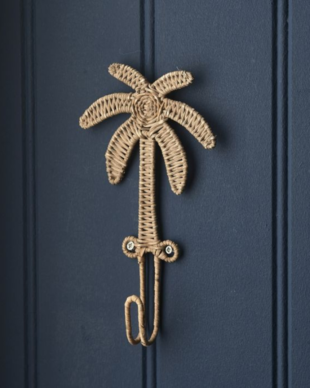 Rustic Rattan Palmen Haken von Rivièra Maison, handgefertigt aus Rattan, vor dunkelblauer Wand befestigt.