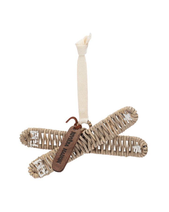 Rustic Rattan Skies Ornament von Rivièra Maison, geflochtene Ski aus Rattan mit hellem Stoffband und RM-Lederetikett vor weißem Hintergrund.