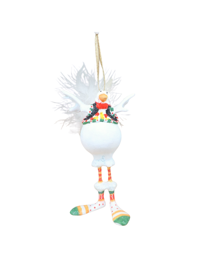 „Mini Snowbird Bernice von schräg vorne – Schneevogel in weiß mit rotem Rock, ausgebreiteten Flügeln und dekorativem grünen Kragen.“