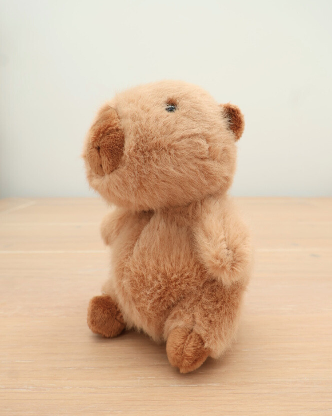 Rückansicht des Capybara Schlüsselanhängers Theo von Bukowski. Sein weicher Körper und die braunen Pfoten sind im Detail zu sehen.