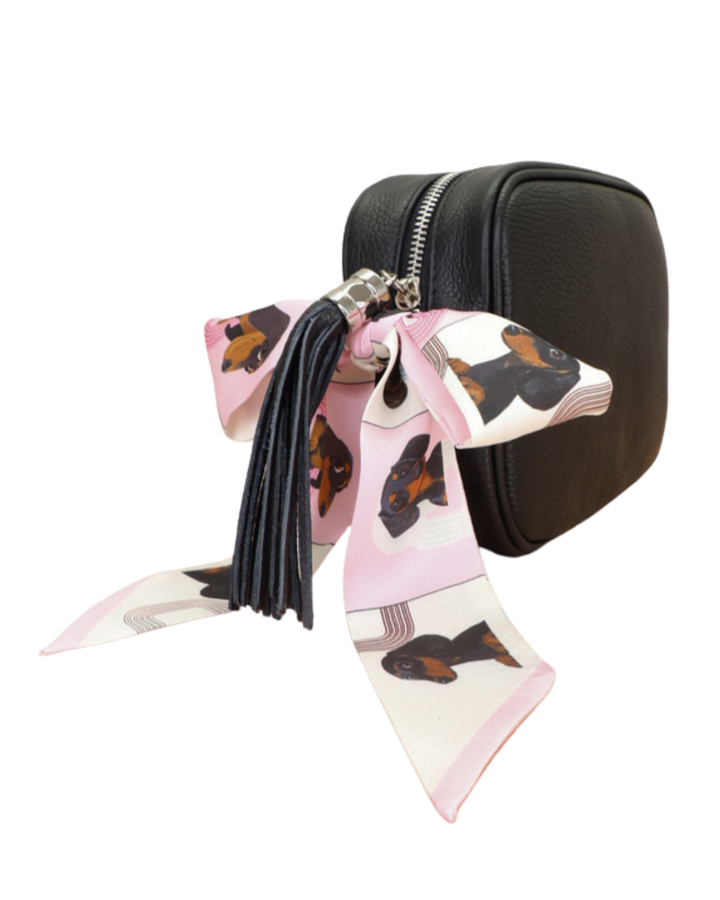 Schwarze Lederhandtasche „Isolde“ mit Bandana-Detail mit Dackelmotiv, seitliche Ansicht mit Fransen und verstellbarem Schulterriemen.