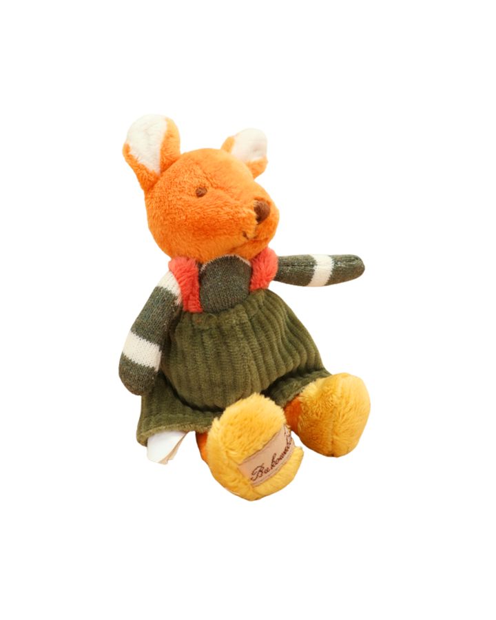 Das orangefarbene Stofftier-Kaninchen mit grünem Pullover sitzt seitlich auf weißem Hintergrund. Die Pfoten sind gelb, und es ist das Markenetikett „Bukowski“ zu sehen.