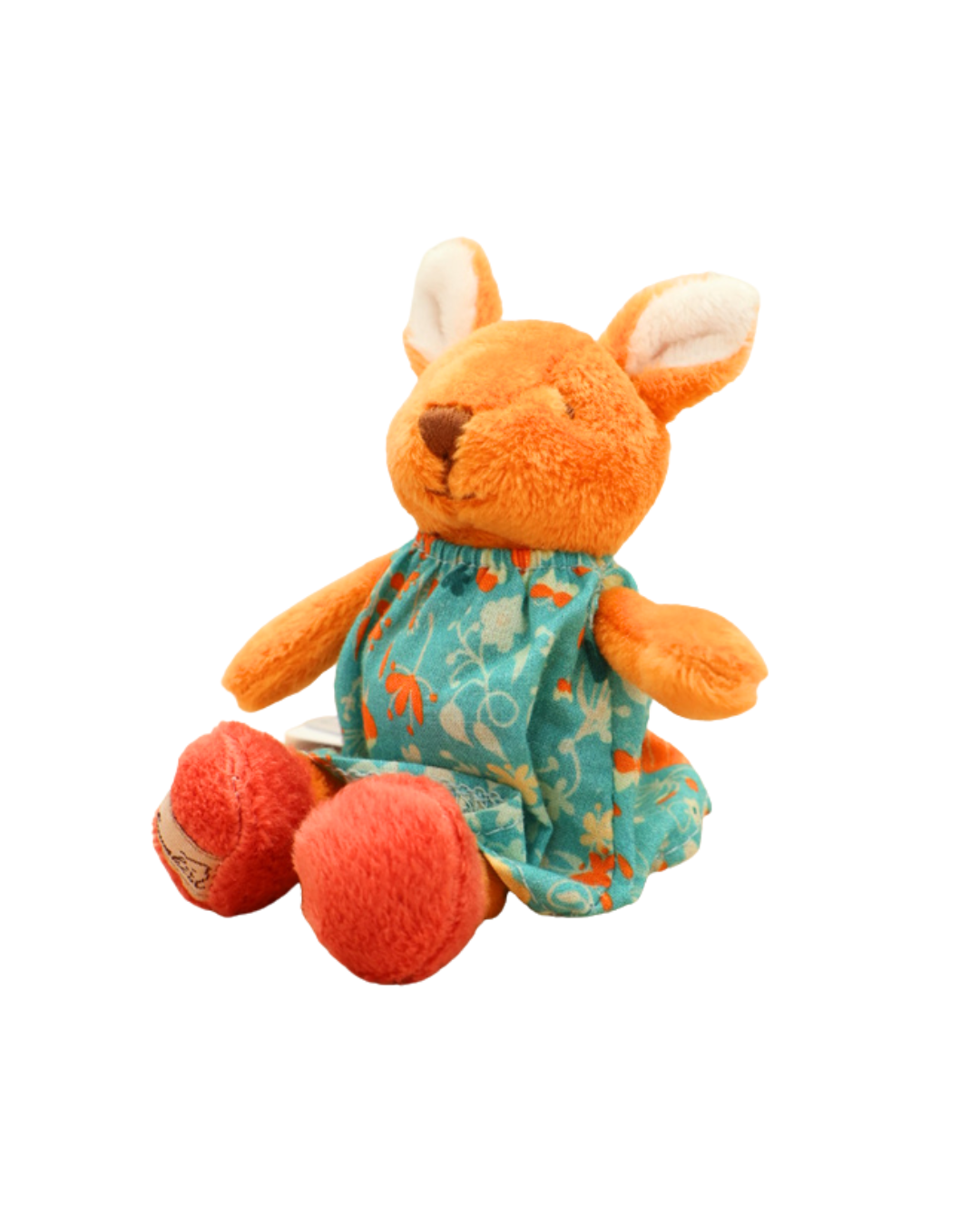 as orangefarbene Kaninchen-Stofftier mit türkisfarbenem Blumenkleid sitzt auf weißem Hintergrund. Die Pfoten sind rot, und das Markenetikett „Bukowski“ ist an einer Pfote befestigt.
