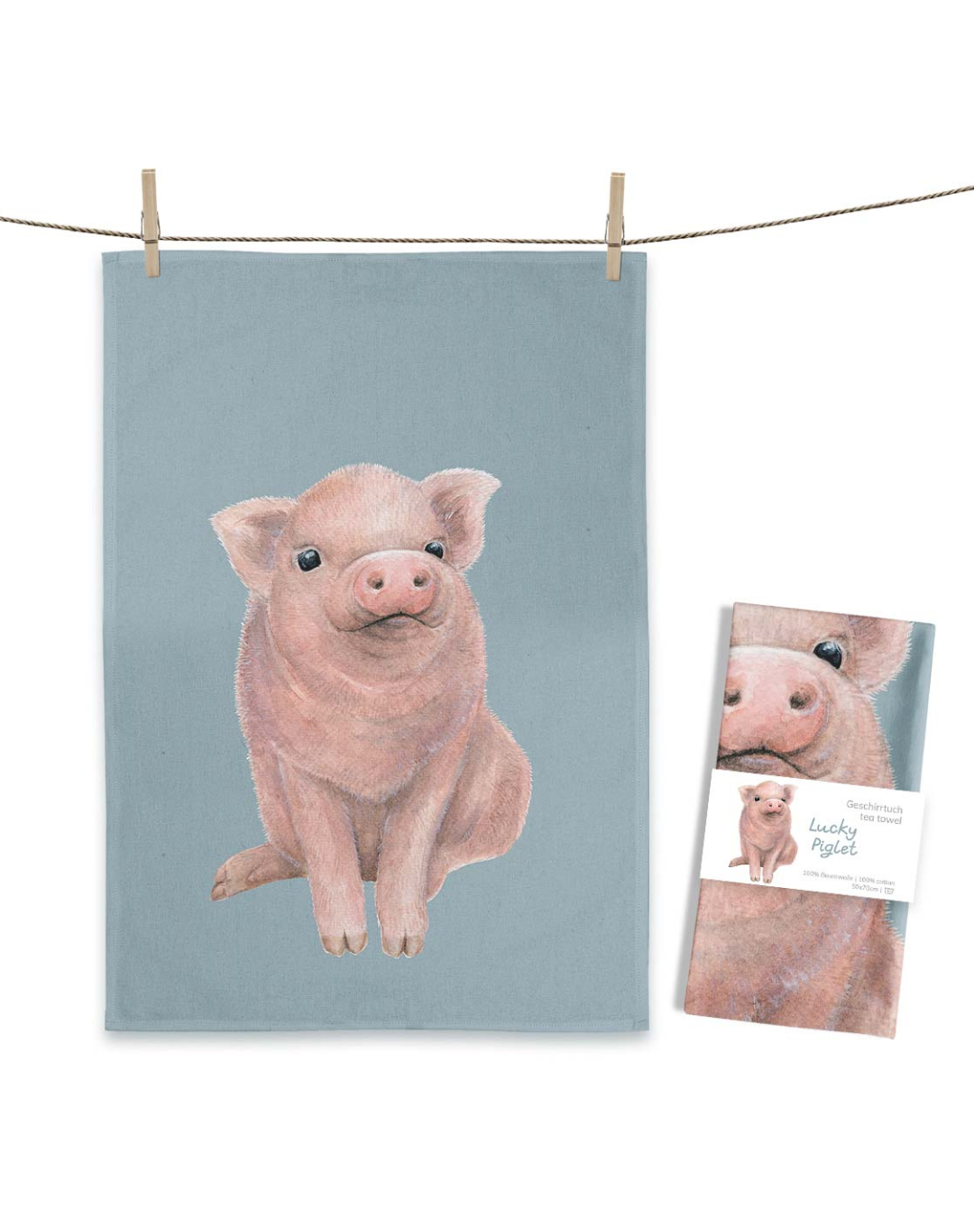 Geschirrtuch „Lucky Piglet“ von Maluu mit rosa Ferkel auf blauem Hintergrund