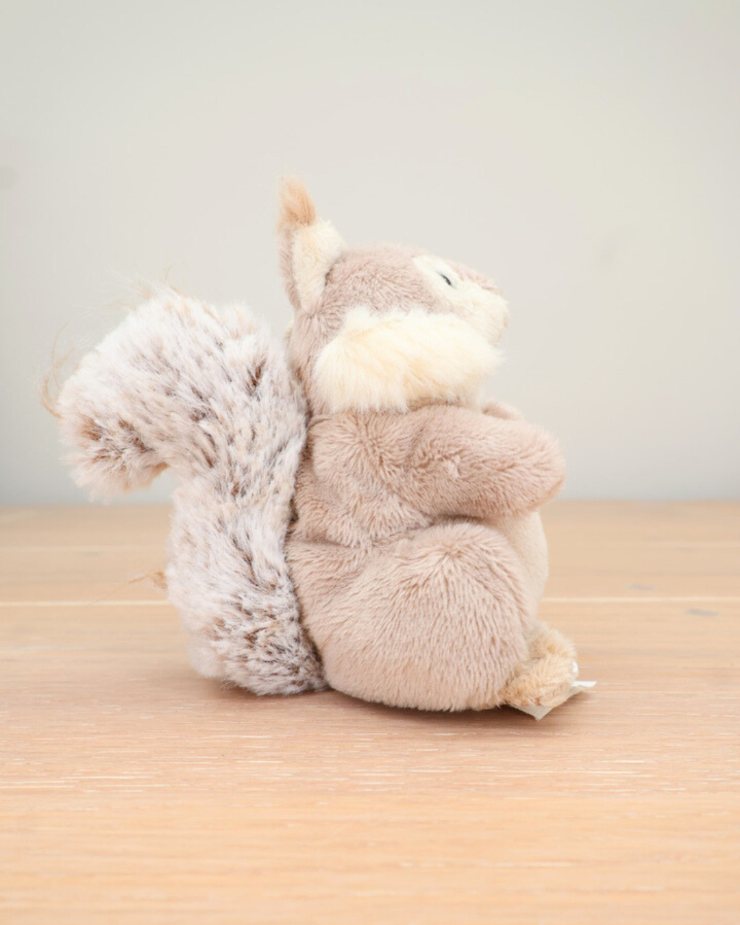 Seitenansicht des beigen Eichhörnchen-Schlüsselanhängers von Bukowski mit flauschigem Schwanz.