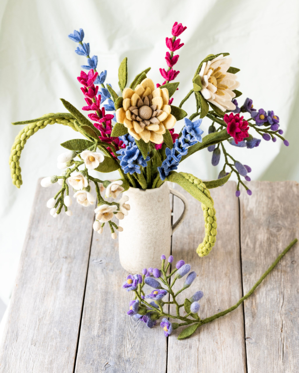 Bunter Filzblumenstrauß mit Sonnenblume von Gry & Sif in heller Vase auf Holztisch