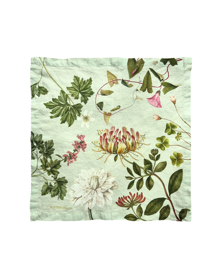 Grüne Stoffserviette mit rauer Oberfläche und Blumenmotiven auf weißem Hintergrund.