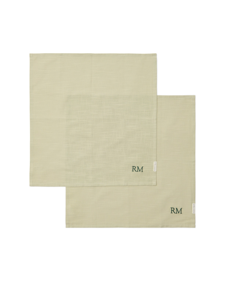 Zwei beige Leinen-Servietten mit Initialen „RM“ von Rivièra Maison, flach ausgelegt auf hellem Hintergrund.