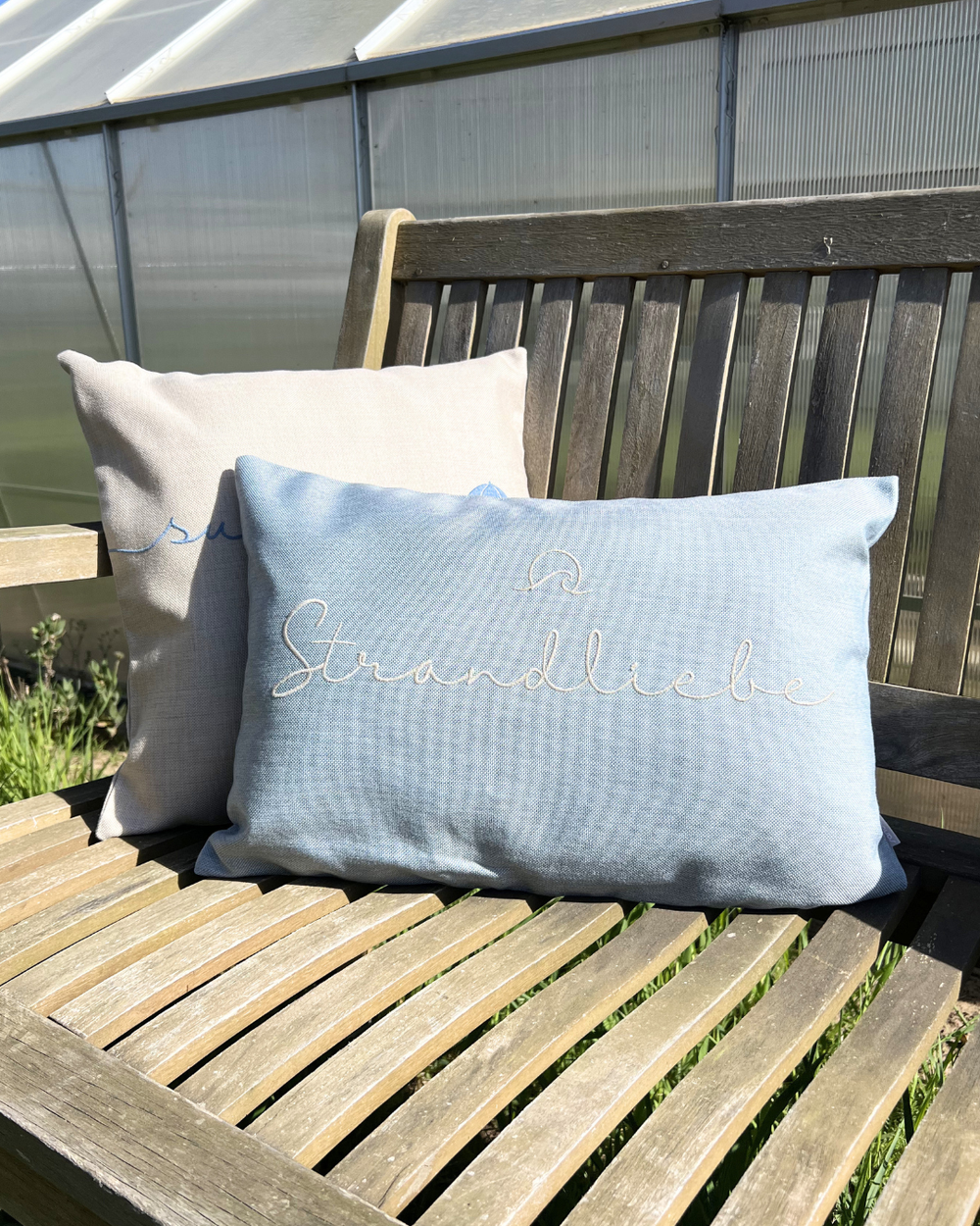 Auf einer Bank dekorierte Summertime und Strandliebe Outdoor-Kissen von Sander.