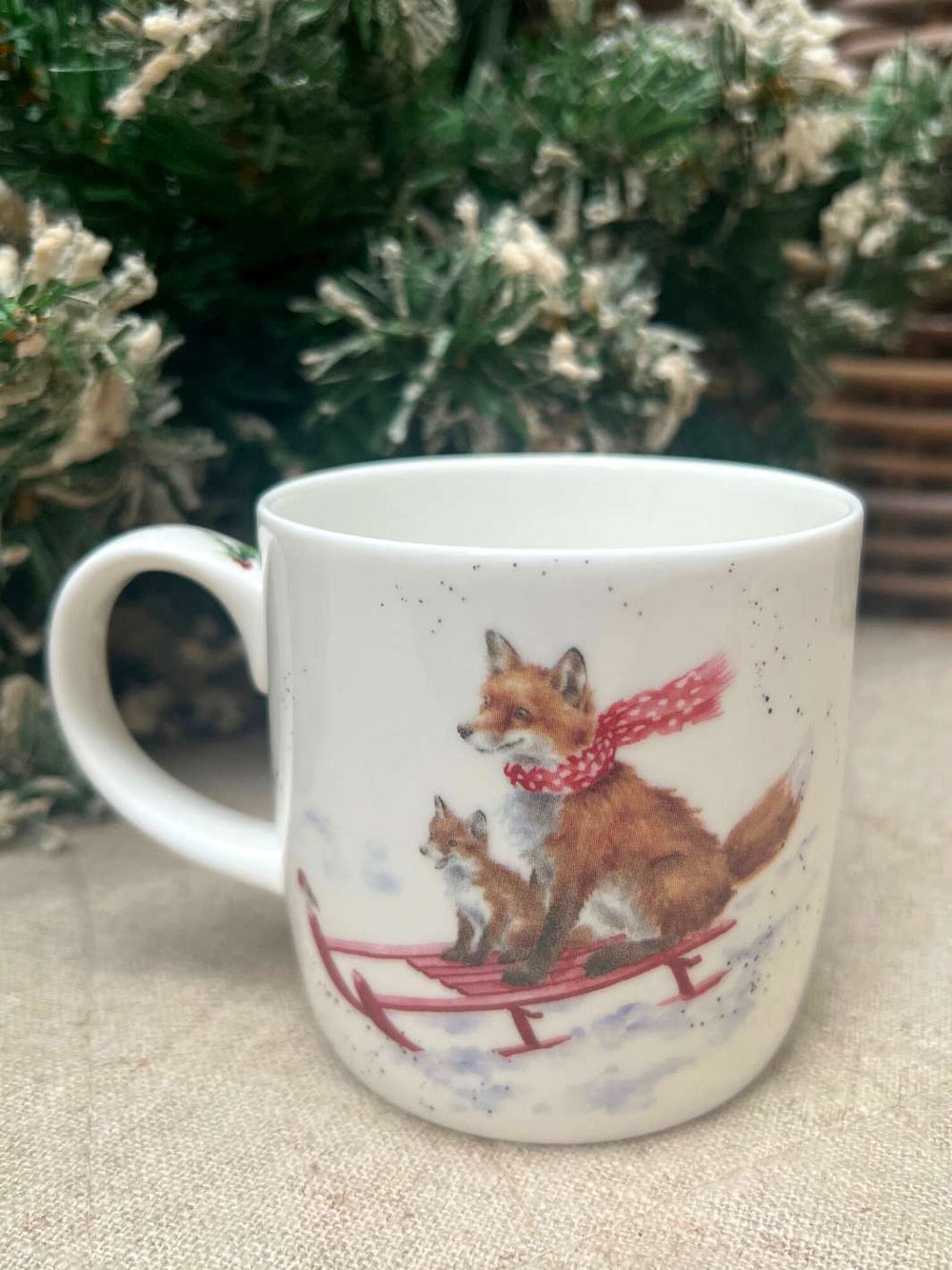 Wrendale Designs Tasse mit einem Fuchs-Motiv. Die Füchse fahren auf einem Schlitten im Schnee.