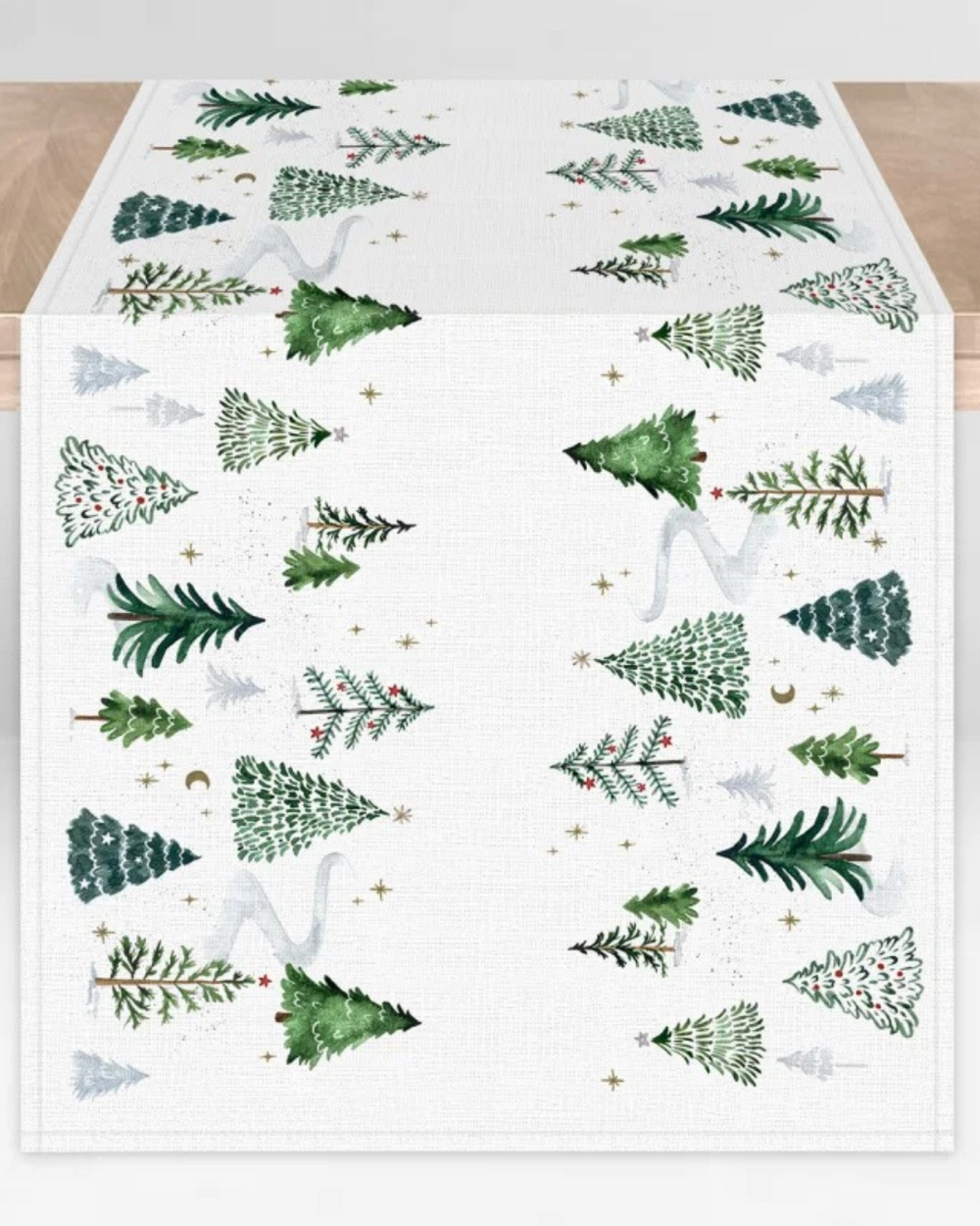 Tischläufer Wintertannen vom Grätz Verlag. Illustriert von Anna Inspira sind Tannenbäume, winterliche Landschaft und goldene Highlights zu sehen. Hier liegt der Tischläufer ausgefaltet auf einem Tisch.