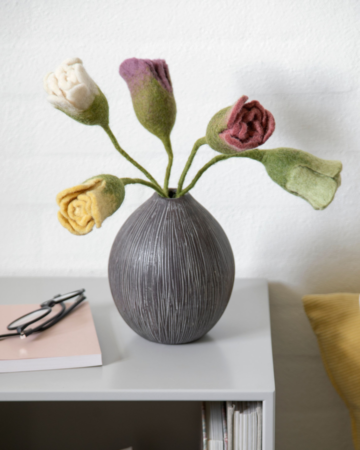 Vase mit Filztulpen-Strauß in verschiedenen Farben auf einem Sideboard