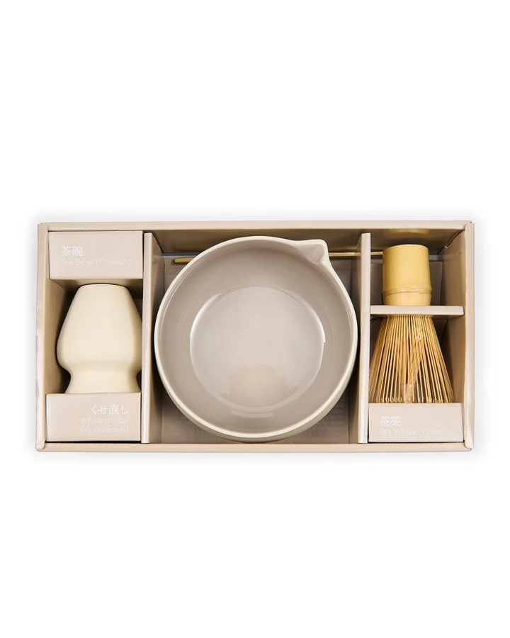 Vierteiliges Matcha Bowl &amp; Whisk Set "Clement" von Riviera Maison. Hellbeige Schüssel und Quirlhalter mit Rührlöffel und Quirl aus hellem Holz. Hier in geöffneter Verpackung.