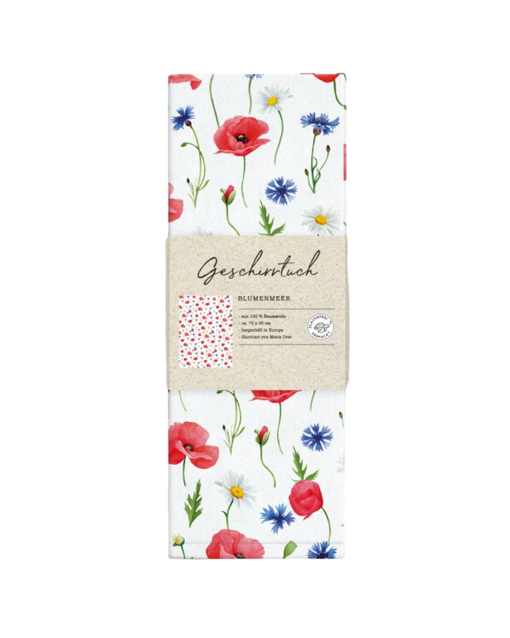 Gefaltetes Geschirrtuch „Blumenmeer“ vom Grätz Verlag mit Papierbanderole, Blütenmuster sichtbar und Produktinformationen auf der Verpackung, frontal fotografiert.