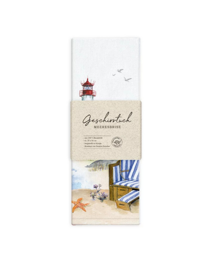 Verpacktes Geschirrtuch Strandkorb Meeresbrise vom Grätz Verlag vor weißem Hintergrund, Illustration von Daniela Drescher mit Küstenlandschaft, Leuchtturm und blau-weißem Strandkorb.