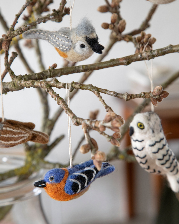 Mehrere Filzanhänger von Gry & Sif als Vögel und Eule dekorativ an Zweigen in einer Glasvase aufgehängt