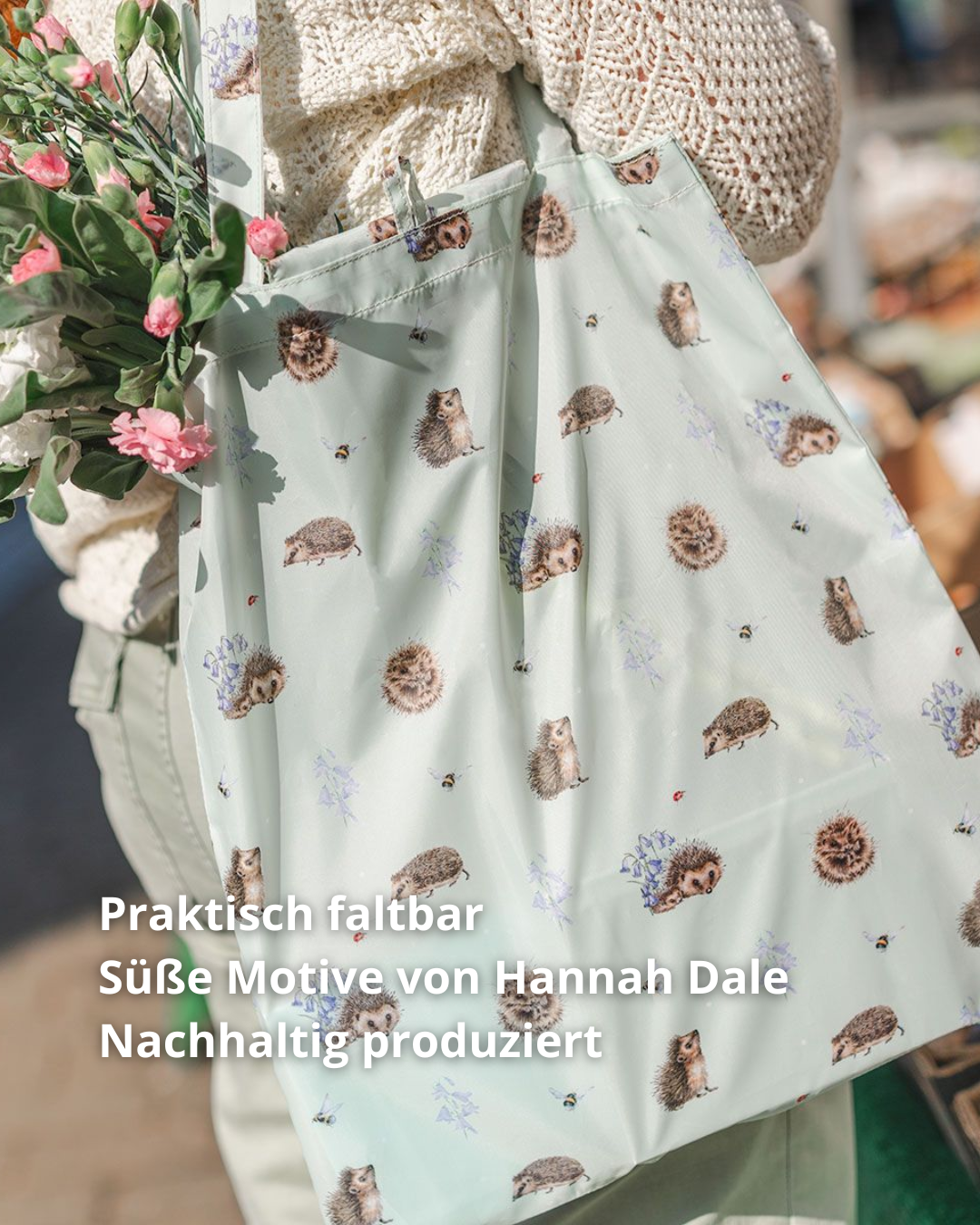 Hellgrüne Igel Einkaufstasche getragen von Wrendale Designs. Das Motiv besteht aus vielen kleinen Igeln Motiven in verschiedenen Posen. Aus der Tasche hängen verschiedene Blumenarten.