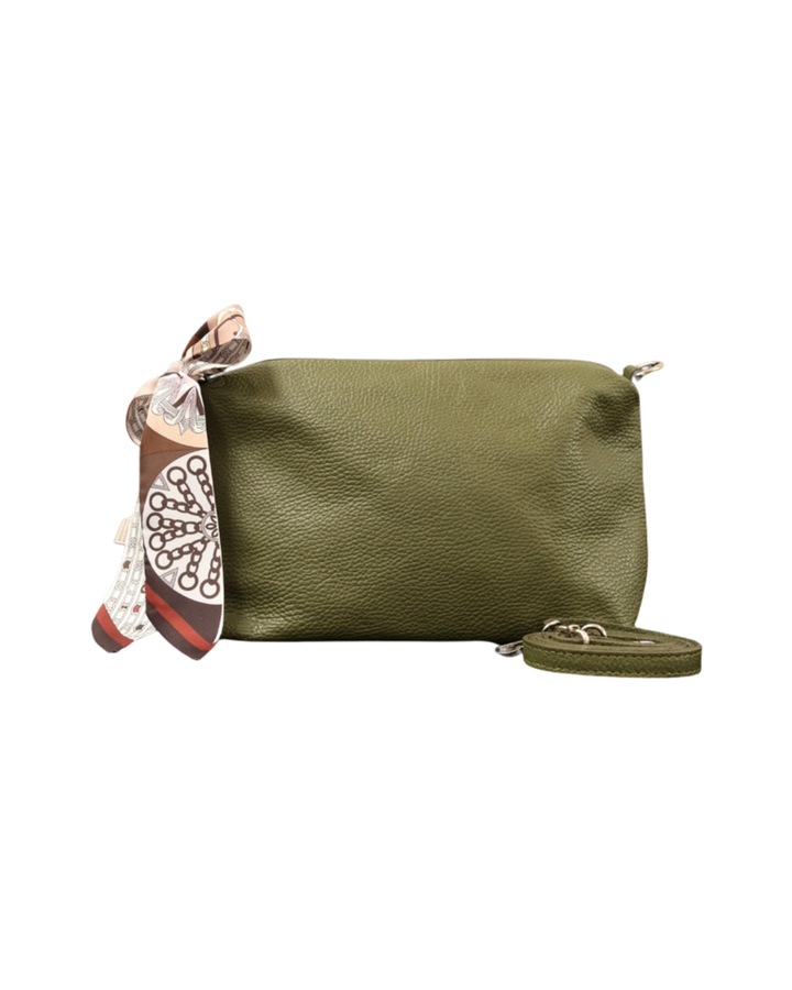 Waldgrüne Leder Handtasche "Brigitte" von Südstrand vor weißen Hintergrund. An dem Verschluss hängt ein Braun/Weißes Tuch. Die kräftige grüne Farbe der Tasche ist gut erkennbar.