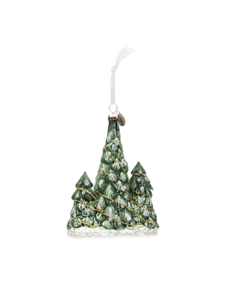 Weihnachtsbaum-Anhänger „Lovely Christmas Tree Ornament“ von Rivièra Maison vor weißem Hintergrund mit verschneiten Tannenbäumen und goldener Girlande.