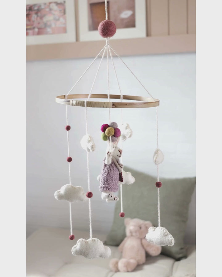 Filz-Mobile von Gry & Sif dreht sich langsam im Raum, aufgehängt vor einer hellen Wand mit Sofa und Kissen im Hintergrund, die Filzanhänger bewegen sich gleichmäßig und ruhig.