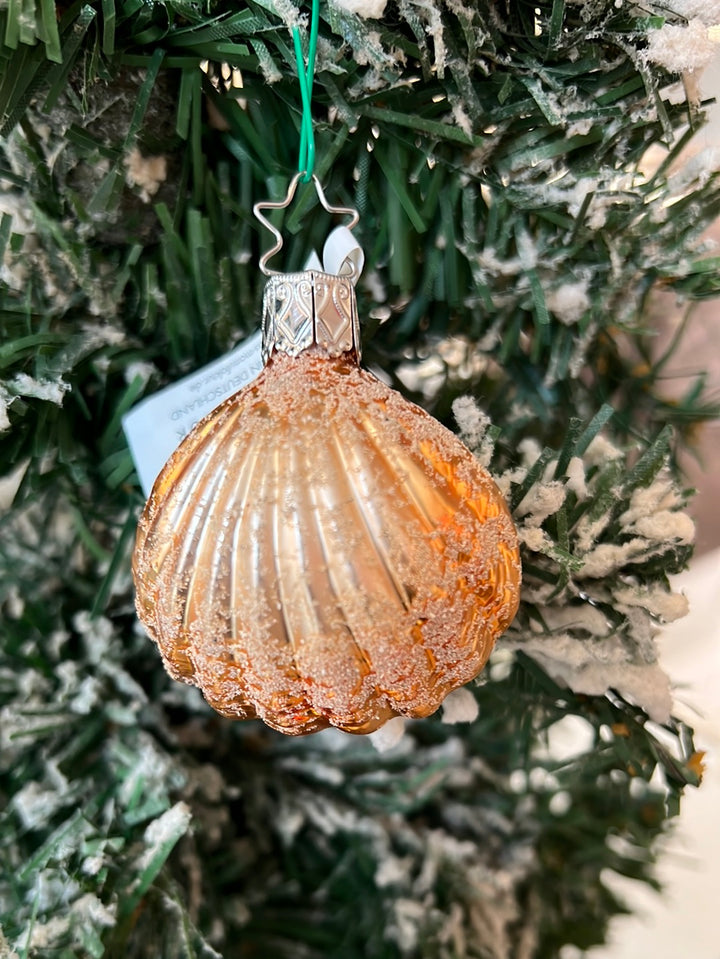 Hübscher, handgefertigter  Muschelanhänger von Inge Glas in orange-gold mit vielen Glitzer Highlights. Hier in einem winterlichen Tannenbaum hängend.